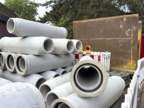 Several concrete pipes stored at the roadside Concrete pipes for sewer construction Laying of sewer