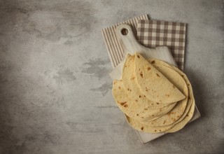 A stack of Mexican tortillas, on a gray table, top view, close-up, no people