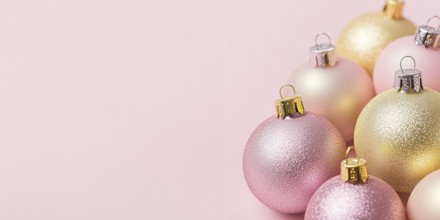 Christmas banner with pink and yellow bauble ornaments on pink background with copy space.