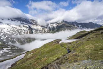 Mountaineer on hiking trail, mountain panorama with high fog in the valley, summit Hochfeiler,