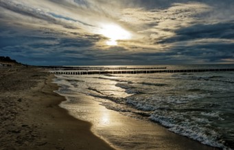 Sunset on the Baltic Sea beach, Ahrenshoop beach in the evening light with clouds, evening mood,