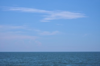 Mediterranean Sea with blue sky, gentle waves and some clouds on the horizon, summer,