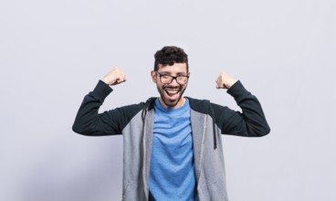 Young man with happy face raising arms in victory gesture isolated. Winner person celebrating