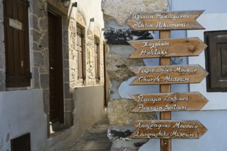 Alley with wooden signs and historic building, tourist atmosphere, Mandraki, Nisyros, Dodecanese,