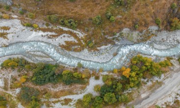 Aerial view, mountain stream Ala Archa flows through the Ala Archa valley, autumnal mountain