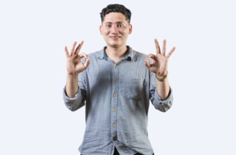 Interpreter person gesturing OK in sign language. Smiling young man gesturing APPROVED in sign