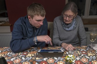 Grandson explains the laptop to his grandmother, Mecklenburg-Vorpommern, Germany, Europe