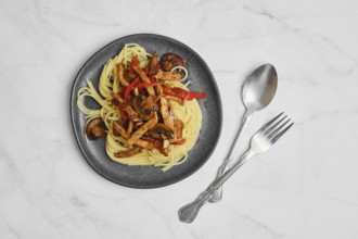 Top view of plate with spaghetti with mushrooms and pork