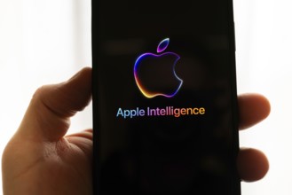 Hand holding iPhone with Apple logo and the text 'Apple Intelligence', bright and modern