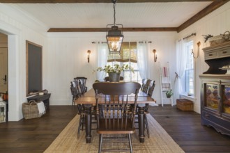 Brown stained pine wood antique reproduction style dining table with high back chairs in dining