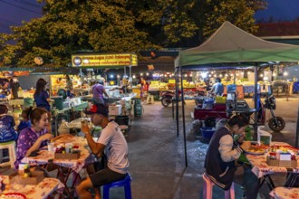 Night market with food stalls and tables at the Chom Thong Food Market in Chom Thong, Thailand,