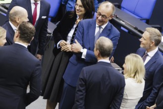 Olaf Scholz (SPD), Federal Chancellor, greets Friedrich Merz, CDU, and Christian Lindner in plenary