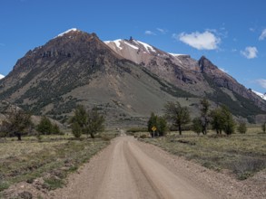 Gravel road X-753 from Chile Chico to Jeinimeni NP, snowcovered mountain range, vocanic rock