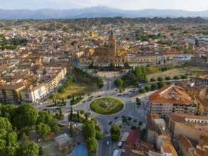 Aerial view of a city with historical centre, roundabout and surrounding landscape, mountains in