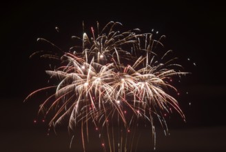 White sparks from fireworks spread across the night sky, Lower Saxony, Germany, Europe