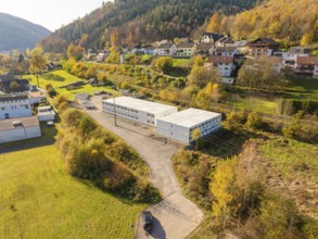 Aerial view of containers next to a village in the middle of an autumnal landscape, refugee