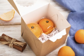 Truffle chocolate tangerine candies on a white wooden background and blue linen textile. Side view,