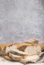 Sliced bread with different kinds of fresh baked bread on a gray concrete background. side view,