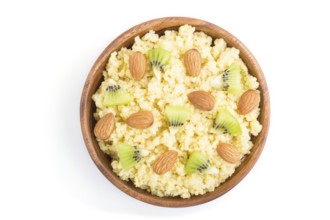 Millet porridge with kiwi and almonds in wooden bowl isolated on white background. Top view, flat