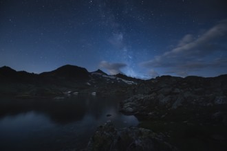 Nocturnal mountain landscape with starry sky and calm water, Milky Way, Krimml, Salzburg, Austria,