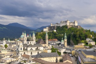 Salzburg's historic city centre with Hohensalzburg Fortress, surrounded by cloudy sky, Salzburg,