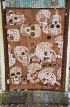 Artistic mosaic with skulls in brown colours and square patterns, Jama pod Krenom, remembrance of