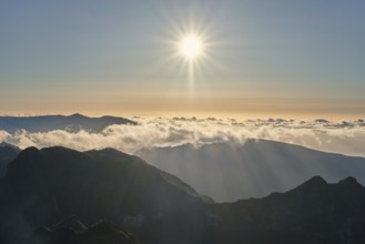 Aerial drone view of mountains over clouds near Pico Ruivo on sunset. Madeira island, Portugal,