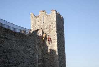 Stonemasons doing maintenance repairs to the stone walls of Framlingham castle, Suffolk, England,