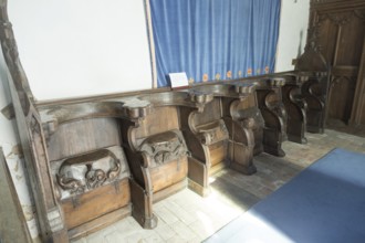 Carved decorated wooden misericord seats in church at Framsden, Suffolk, England, UK