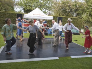 People performing dances to 1940s swing music during a country fair, Helmingham Hall, Suffolk,