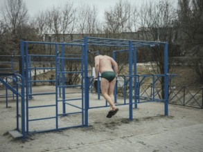 Man doing pull-ups in a bathing facility in the Severno Saltivka neighbourhood. The neighbourhood