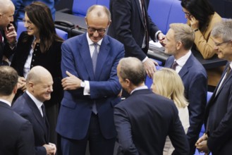 Olaf Scholz (SPD), Federal Chancellor, greets Friedrich Merz, CDU, and Christian Lindner in plenary