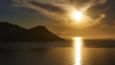 Peaceful scenery of a sunrise between mountains and reflecting sea, Mani peninsula, Peloponnese,