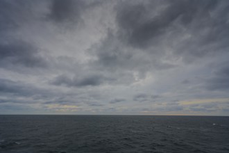 Sweeping view of a grey, cloudy ocean, creating a calm and melancholic atmosphere, North Sea,