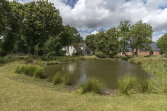 Manor house from 1920, in front the extinguishing pond, on the right the former horse stable,