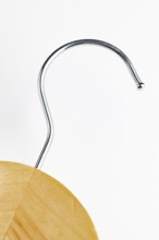 Close-up of the hook of a wooden coat hanger, white background