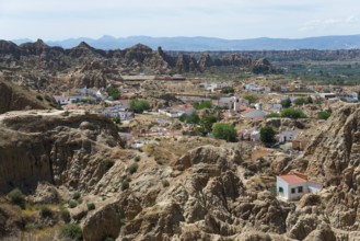 A village of white houses stretches along the rocky and picturesque mountain landscape, view from