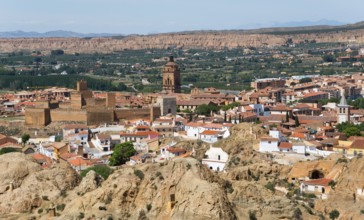 Panoramic view of a city with historical buildings, church and city wall, surrounded by a hilly