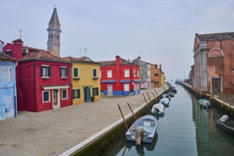 Colorful houses beside the waterway at 'Fondamenta di Pizzo' with boats lying in the water on the