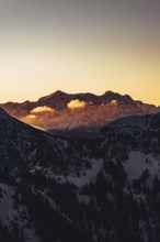 A woman's ski tour at sunrise on the Tegelberg in the Allgäu in the Ammergebirge, Bavaria, Germany,