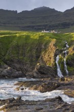 Houses against a mountain backdrop, rocky coast, sea, surf, Vidareidi, Vidoy Island, Viðareiði,