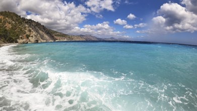 Deep blue sea with a distant coastline and white fleecy clouds in the sky, Kato Lakkos Beach, still