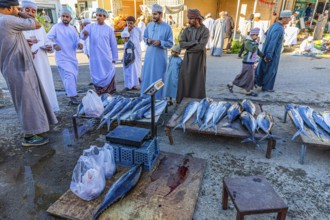 Local shoppers haggle over the price when buying fish at the weekly market market in Bahla, Bahla