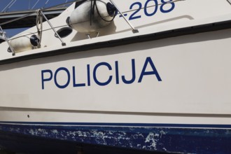 Close-up of Police written in Croatian language on side of maritime police patrol boat, Port of