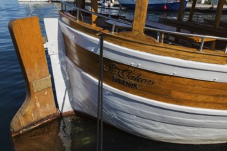 Rudder on docked white painted and varnished wooden boat in harbour in late summer, Sibenik,