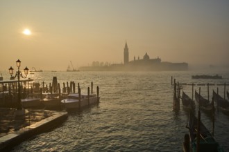 View from 'Ponte della Paglia' bridge on church 'Giorgio Maggiore' on a foggy morning at sunrise in