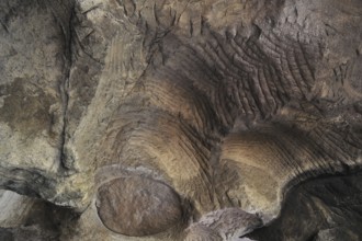 Grooves and circles in the sandstone rock from carving millstones at the Hohllay cave in Berdorf,