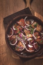 Fried meat, pork kebab, ketsi in a clay pan, with red onions and herbs, homemade, no people