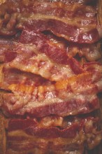 Fried bacon on a cutting board, top view, close-up, homemade, breakfast, no people