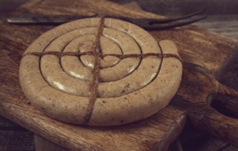 Raw spiral sausages, on a wooden board, top view, no people